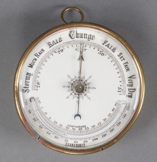 An aneroid barometer with enamelled dial contained in a gilt metal case 13cm 