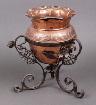 An Arts and Crafts embossed copper jardiniere raised on a wrought iron stand 30cm h x 21cm diam.