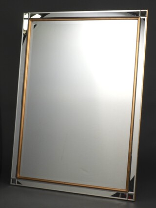 A 20th Century rectangular bevelled plate mirror contained in a decorative gilt frame 136cm x 105cm 