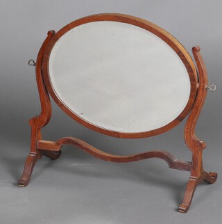 An oval bevelled plate dressing table mirror in a mahogany swing frame 43cm h x 48cm w x 25cm d 
