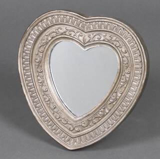 An easel dressing table mirror contained in a heart shaped frame