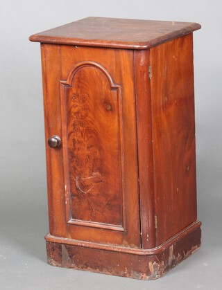 A 19th Century mahogany pot cupboard enclosed by an arched panelled door, raised on a platform base 75cm h x 42cm w x 39cm d 