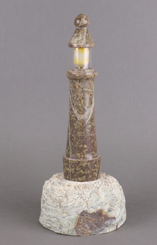 A carved Cornish serpentine table lamp in the form of a light house 40cm h (top is chipped)