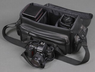 A Nikon F100 camera with a HYOA 55mm skyline B lens, a Regent 55mm skylight lens, an APO macro 70-300mm lens, contained in a cloth carrying case 