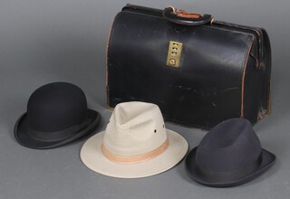 A black briefcase, a gentleman's bowler hat by Dunn size 7, a Trilby by Macqueen size 7 and 1 other hat size 7