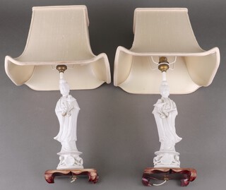 Two blanc de chine porcelain figures converted to table lamps on wooden bases 27cm, together with a brown and ebonised table lamp in the form of an urn 28cm 