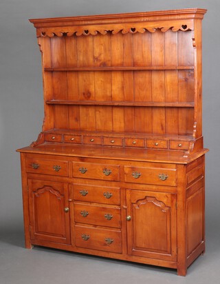 A Georgian style mahogany dresser with moulded cornice, the raised back fitted 2 shelves above 7 short drawers, the base fitted an arrangement of 6 drawers flanked by cupboards enclosed by arched panelled doors 198cm h x 151cm w x 54cm d 