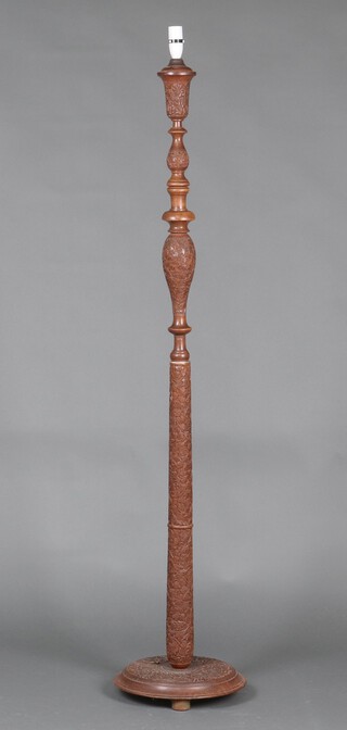 A carved Burmese hardwood standard lamp, raised on a circular base 155cm h x 33cm 