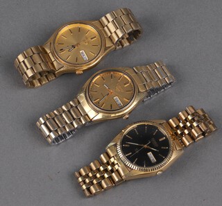 Two gilt cased Seiko 5 day date wristwatches on gilt bracelets and another with black dial 