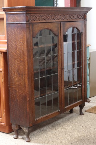 An oak display cabinet fitted shelves enclosed by lead glazed panelled doors, raised on cabriole supports 81cm h x 114cm w (formerly the top of a bureau bookcase) 