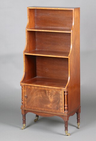 A Georgian style inlaid mahogany 3 tier waterfall bookcase, the base fitted a cupboard enclosed by a panelled door, raised on turned supports 