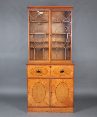 A Regency satinwood and figured walnut, crossbanded and inlaid rosewood secretaire bookcase with moulded and dentil cornice, fitted adjustable shelves enclosed by astragal glazed panelled doors, the secretaire drawer fitted figured walnut veneered drawers and pigeon holes, the base fitted 3 drawers with brass swan neck drop handles, having ivory escutcheons, raised on a platform base 212cm h x 95cm w x 50cm d Ivory Exemption Certificate GFTMNXM1