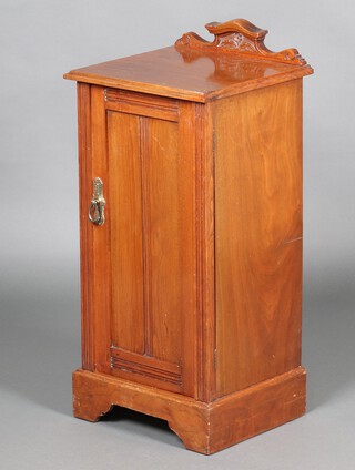 An Edwardian carved walnut bedside cabinet with shaped raised back fitted a panelled cupboard, raised on bracket feet 84cm h x 38cm w x 35cm d 