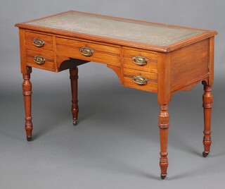 A Victorian bleached walnut writing table with inset green leather writing surface above 1 long and 4 short drawers, raised on turned supports with ceramic casters 75cm h x 110cm w x 50cm d 