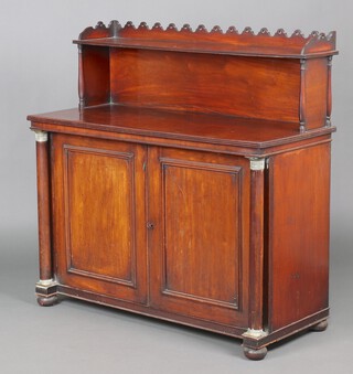 A Regency mahogany chiffonier, the raised back with arched and pierced 3/4 gallery above a recess, the cupboard enclosed by a panelled door, flanked by 2 turned columns with brass capitals, raised on bun feet 119cm h x 120cm w x 51cm d  