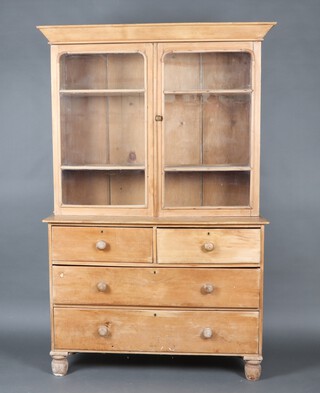 A Victorian pine dresser with moulded cornice, fitted shelves enclosed glazed panel doors, the base fitted 2 short and 2 long drawers with turned handles, raised on bun feet 204cm h x 129cm w x 48cm d 