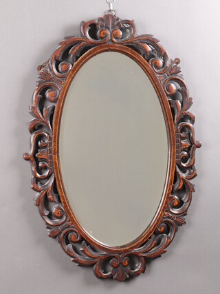 A Victorian oval bevelled plate wall mirror contained in a carved and oak pierced frame, the base of the mirror is etched Cro7PP16  80cm x 55cm 