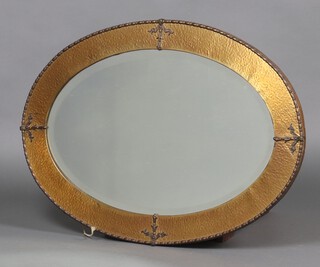 An Art Nouveau oval bevelled plate wall mirror contained in a planished gilt frame 86cm  x 61cm 
