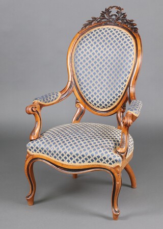 A 19th Century Continental carved walnut open arm chair, surmounted by a carved leaf garland, upholstered in yellow and gold fabric, the seat of serpentine outline, raised on cabriole supports 115cm h x 60cm w x 50cm d  