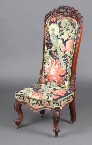 A Victorian pierced and carved mahogany nursing chair, the seat of serpentine outline, the pierced cresting rail carved flowers, upholstered with pheasant patterned material,  raised on cabriole supports 114cm h x 48cm w x 40cm d  