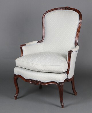 An Edwardian carved mahogany show frame armchair with carved floral cresting rail, upholstered in turquoise patterned material, raised on cabriole supports 106cm h x 67cm w x 62cm d (seat 28cm x 32cm) 