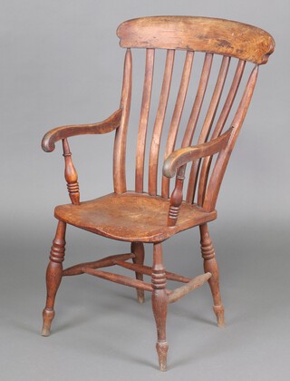 A 19th Century elm and beech stick and bar back Windsor kitchen carver chair with solid seat, raised on turned supports with double H framed stretcher, the back of the seat marked F.W 105cm h x 44cm w x 45cm d 