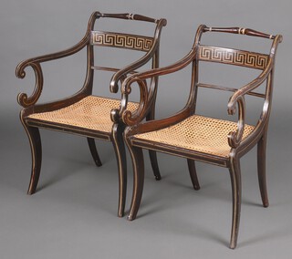 A pair of 19th Century painted open arm chairs with turned rail backs, the mid rail with Grecian key decoration, woven cane seats, raised on sabre supports 81cm h x 55cm w x 47cm d 