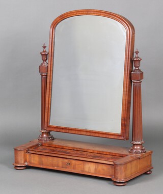 A William IV arched plate dressing table mirror in a mahogany frame, supported by a pair of turned and fluted columns, the base fitted a recess with sliding lid, raised on bun feet 90cm h x 72cm w x 32cm 
