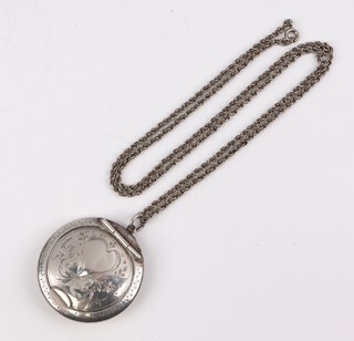 A silver compact with engraved decoration Birmingham 1922 on a plated necklace 70cm 