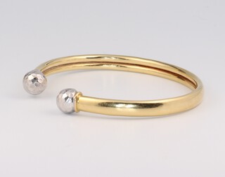 An 18ct yellow gold sprung torque bangle, gross weight 10.6 grams 