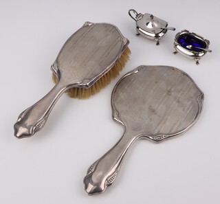A silver engine turned hand mirror and hair brush with geometric decoration, Birmingham 1919 and a silver mustard and salt with spoons Birmingham 1923, weighable silver 76 grams 