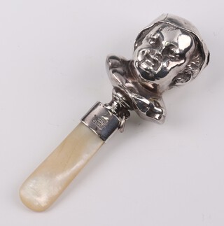 An Edwardian silver mounted rattle/teether in the form of a babies head Birmingham 1903, with mother of pearl teether 11.5cm 
