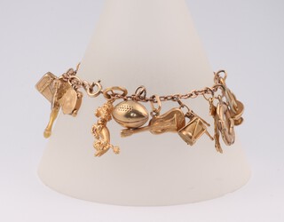 A 9ct yellow gold charm bracelet with 17 gold charms including poodle, rugby ball, gondola etc, gross weight 29.2 grams 