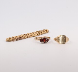 A 9ct yellow gold bracelet 18cm, a 9ct yellow gold signet ring size J 1/2 and a ditto set with garnets size K, gross weight 5.7 grams 