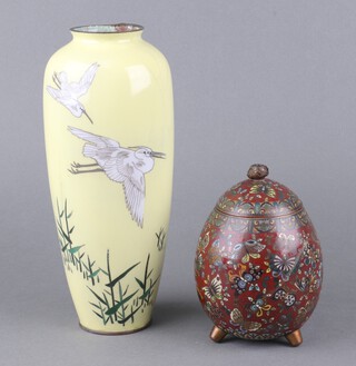 A Japanese yellow ground cloisonne vase decorated storks in flight 24cm (crack and chip to the top, base is loose) together with a red ground cloisonne enamelled urn and cover decorated butterflies 12cm (finial loose)