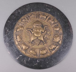 A circular embossed Tibetan plaque decorated Garuda surrounded by 12 Tibetan zodiac signs, within a circular marble plaque, 41cm diam. 