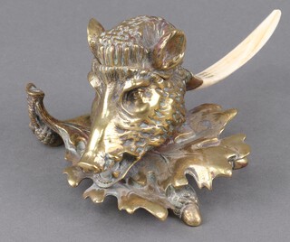 A Victorian cast brass inkwell in the form of a wild boar's mask on oak leaves, with boar tusk handle 10cm x 20cm 