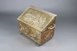 A twin handled wedge shaped embossed brass coal box decorated medieval court scenes with procession and figures cooking 48cm h x 61cm w x 38cm d 