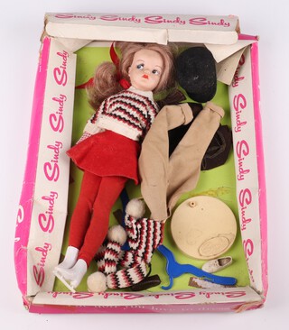 Pedigree Toys, a mid 1960's Sindy Doll in skating girl outfit together with a horse riding outfit (missing the shirt), contained in a fitted plastic carry bag with branded Sindy fitted card backing 