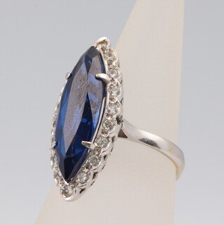 An 18ct white gold elliptical dress ring set with a paste blue stone and paste brilliant cut stones, size M, 6.3 grams 