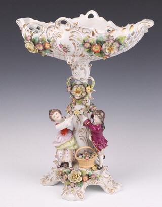 A 20th Century Sitzendorf centre piece with figures supporting a basket above them, applied with flowers on a Rococo base 37cm h 