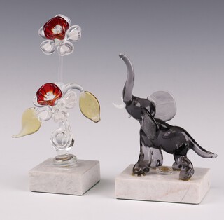 A Continental coloured glass figure of a standing baby elephant on a white marble base 13cm, ditto of flowers 17cm 