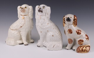 A Victorian Staffordshire white glazed figure of a Spaniel with gilt decoration 26cm, ditto 25cm and a smaller ditto 20cm 