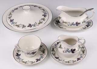 A Royal Doulton Burgundy pattern part dinner and tea service comprising 6 tea cups, 6 saucers, 6 two handled bowls, a milk jug and sugar bowl, sauce boat and stand, 2 serving plates, 12 side plates, 6 medium plates, 6 dessert plates, 6 dinner plates, 2 tureens and covers 