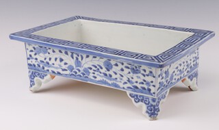 An early 20th Century Chinese rectangular jardiniere with Greek key pattern rim and scrolling flowers, on bracket feet 31cm