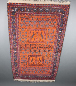 An orange and blue ground Belouche rug with 2 rectangular panels decorated goats within a multi row border 204cm x 117cm
