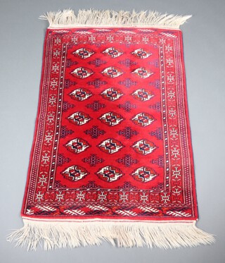 A red and blue Afghan rug with 18 stylised octagons to the centre within a multi row border 152cm x 99cm 