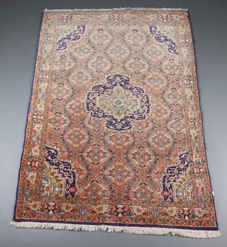 A pink and blue ground North Persian rug with central medallion within a multi row border 177cm x 117cm 