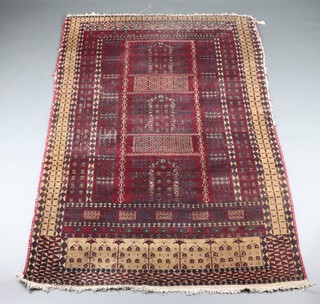 A red and black ground Belouche rug with rectangular central medallion divided into 3 arches, within a multi row border 212cm x 136cm 