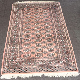A pink and black ground Bokhara rug with 39 octagons to the centre within a multi row border 198cm x 129cm
